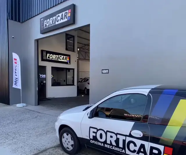 Fachada da Fortcar Oficina Mecânica em Sapucaia do Sul, com o carro adesivado da oficina na entrada
